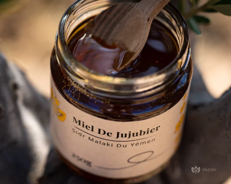 Pot De Miel De Jujubier Sidr Malaki Posé Dans Un Arbre, Avec Une Cuillère En Bois Laissant Couler Le Miel.